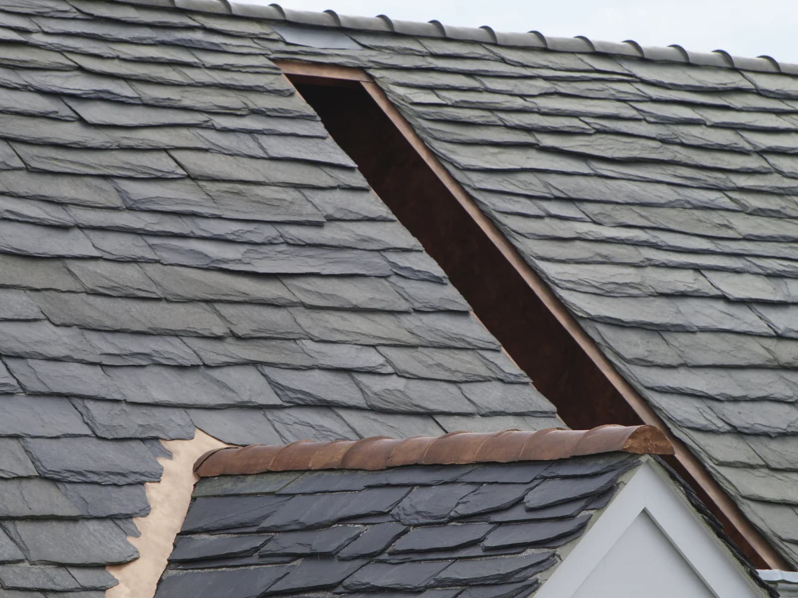 Close view of a slate roof, two planes meeting in an open copper valley